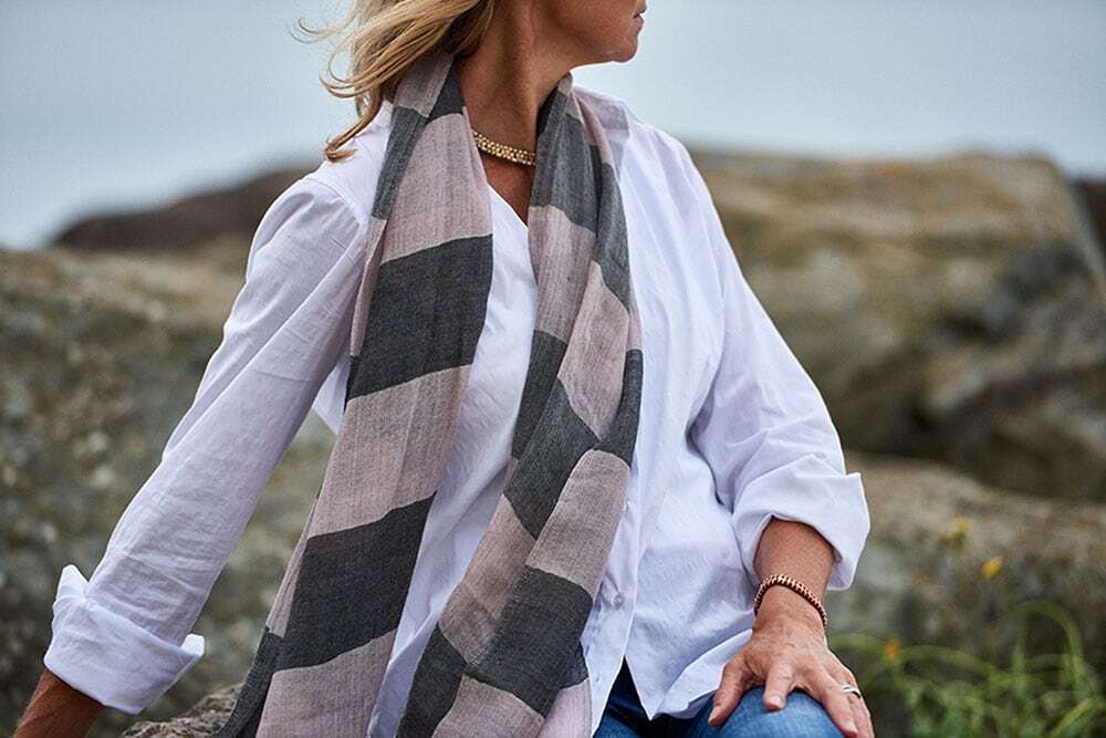 must have accessories, on location beach photoshoot with blonde model wearing scarf and looking out at sea