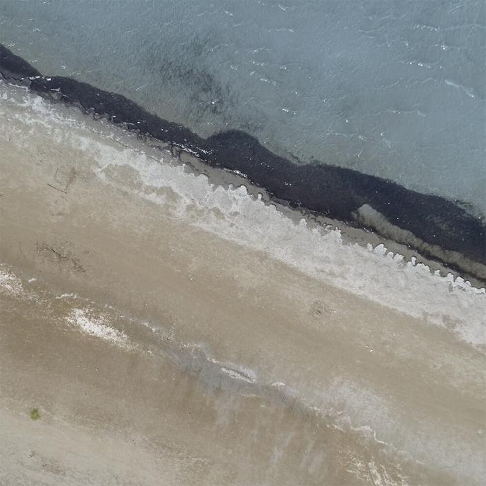 Aerial view of Brighton shoreline with white sand and clear water taken on drone from above